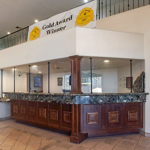 The image shows a reception desk area with a wooden counter and a banner above reading 