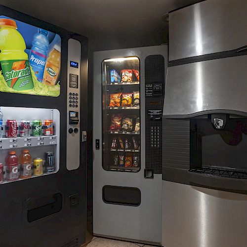 The image shows a set of vending machines: a drink machine on the left, a snack machine in the middle, and an ice dispenser on the right.